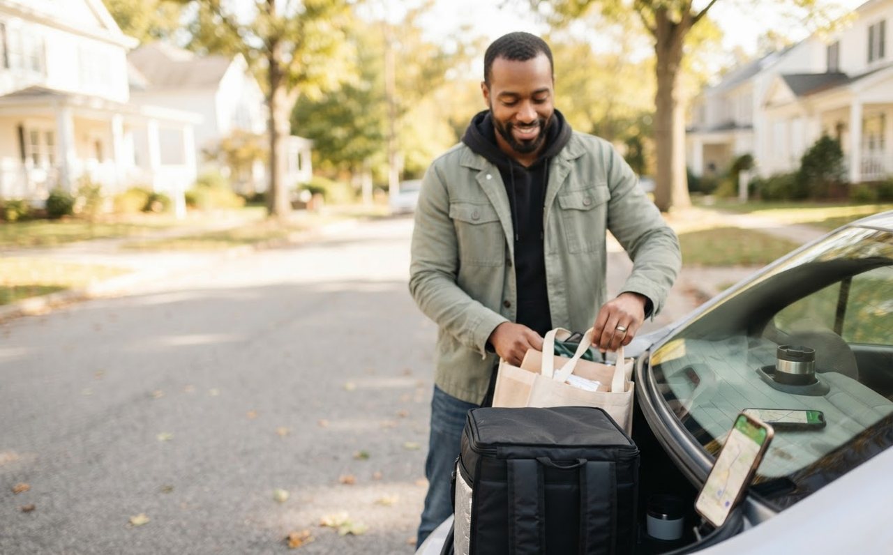 A man preparing for early side-work deliveries on a suburban street — www.changeyourlife.money